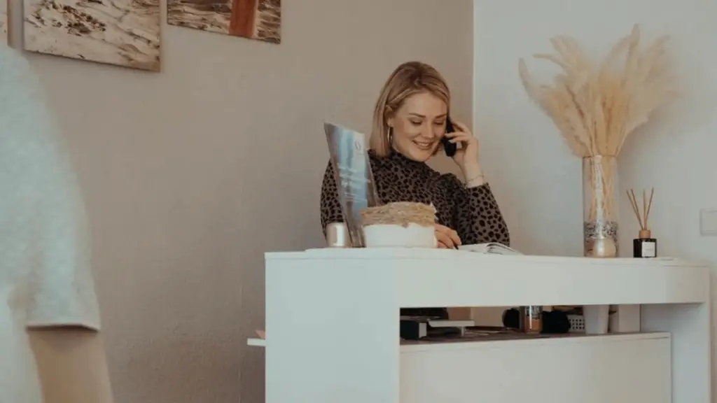 Julia Plünnecke in ihrem 20qm Studio am Telefon hinter der Theke, kurz bevor sie bei der Salmana Beauty Academy anfing
